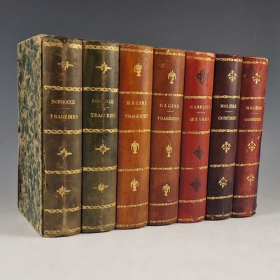 plusieurs vieux livres sont alignés sur une surface grise