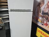 un réfrigérateur blanc dans un magasin, avec une photo accrochée au mur derrière lui