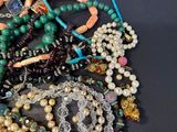 a pile of assorted beads and necklaces on a table
