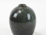 a black vase that is sitting on a white surface