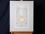 un chevalet sur lequel est posé une œuvre d'art, sur fond noir