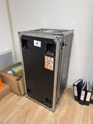 a large black box sitting on the floor next to a pile of books