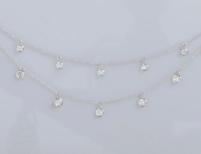 un collier en or blanc orné de cinq diamants sur une chaîne
