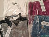 three pairs of jeans and a t - shirt in a plastic bag