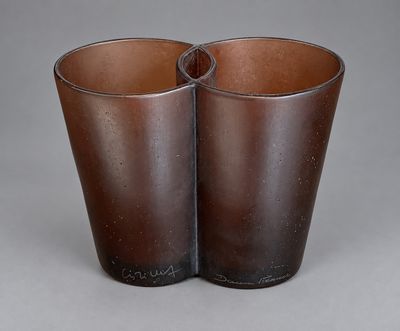 une paire de vases en verre marron posés sur une surface grise