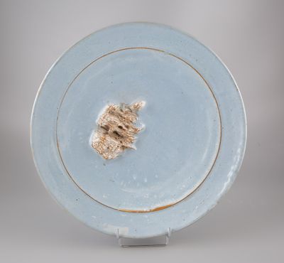 une assiette bleue sur laquelle se trouve un petit morceau de nourriture