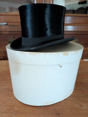 a black top hat sitting on top of a white box