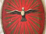 a red plate with a bird on it sitting on a table