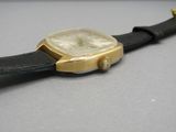 une montre posée sur un bracelet en cuir noir