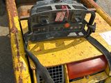 a small yellow machine with a black handle on it
