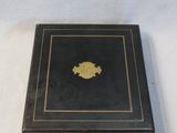 a small black box with a gold emblem on it