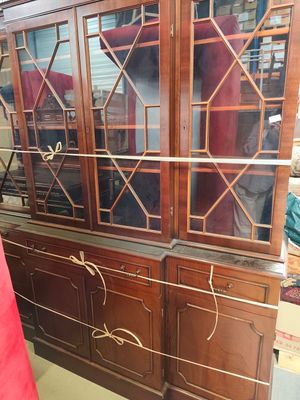 a wooden china cabinet with glass doors in a room