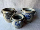trois vases bleus et blancs posés sur une surface blanche