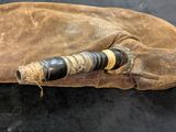 an old leather bag with a knife on top of it on a table