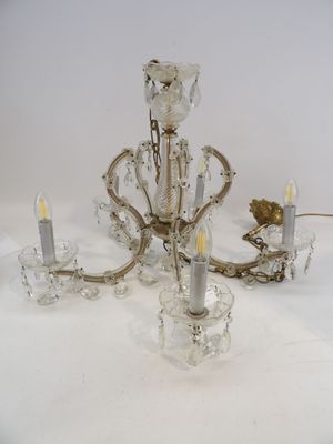 un lustre en cristal avec des bougies posées sur une table blanche