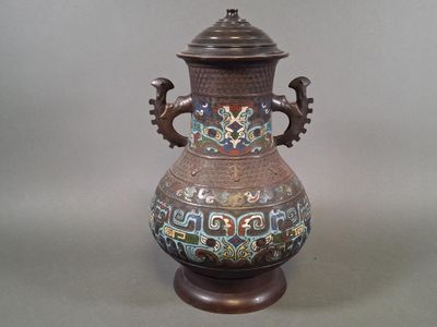 a vase with a lid sitting on a table