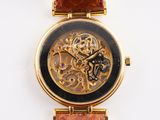 a gold wrist watch with a black face and a brown strap