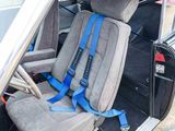 two seats in the back of a car with a blue seat belt