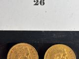 two gold sovereigns in a box on a black surface