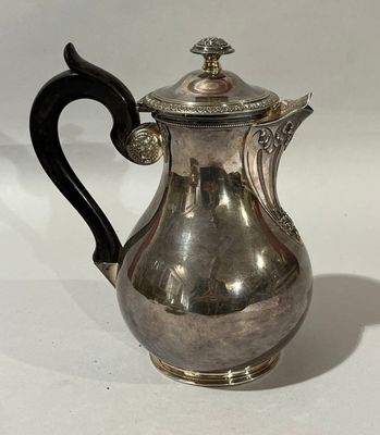 une cafetière en argent avec une poignée noire sur un fond blanc