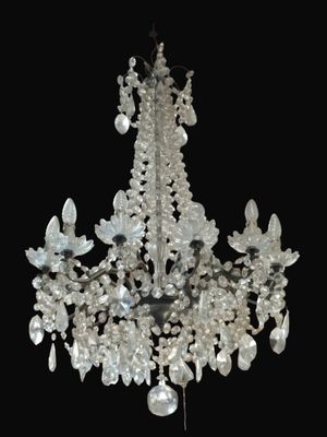 a crystal chandelier hanging from a black ceiling