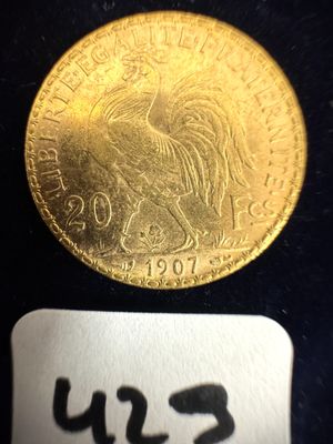 l'image d'une pièce d'or sur un fond noir, à côté d'une étiquette