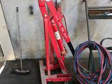 a picture of a red hydraulic jack in a garage