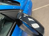a close up of a car ' s side mirror with a dog sitting in the passenger seat