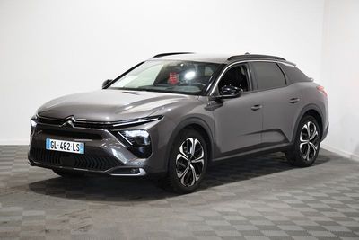 Le SUV gris est garé dans une pièce dont le sol est en damier.