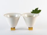 deux vases blancs contenant chacun une feuille verte