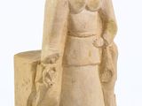 une statue représentant une femme tenant un panier et un sac