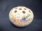 a small vase with a tag on it on a black background