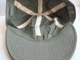 un chapeau vert orné d'un ruban blanc