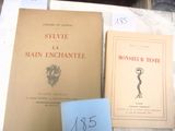 Plusieurs livres sont posés sur une table recouverte d'une nappe blanche.