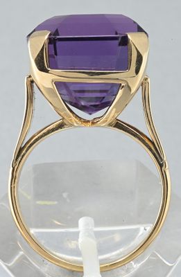 a close up of a ring with a purple stone in it
