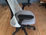 a black and white office chair on a hard wood floor