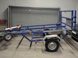 une petite remorque à laquelle est attelée une autre remorque, dans un garage