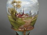 a vase with a painting on it on a stand