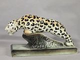 figurine of a leopard on a rock on a white background