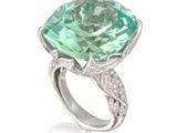 une image représentant une bague ornée d'une grosse pierre verte entourée de diamants