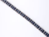 a close up of a blue and white bracelet on a white surface