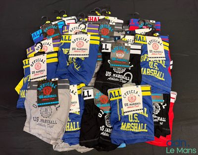 Plusieurs paires de boxers pour homme sont disposées sur une surface noire