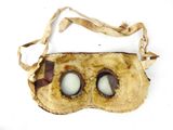 a brown mask with two eyes on it on a white surface
