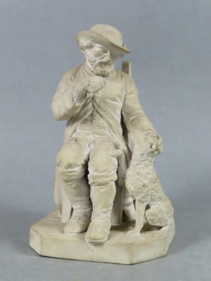 statue représentant un homme avec un chien, assis sur un bloc de pierre