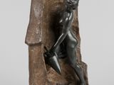 une statue en bronze représentant un homme avec une chèvre sur un rocher