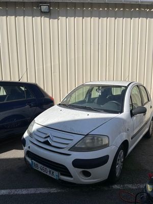 une petite voiture blanche garée à côté d'une voiture bleue