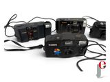 three cameras are sitting next to each other on a white surface