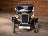 a old car parked in a garage with a brick wall in the background
