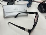 several pairs of sunglasses are sitting on a table next to a pair of glasses