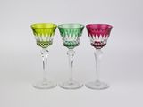 trois verres à vin de couleurs différentes posés les uns à côté des autres sur une surface blanche